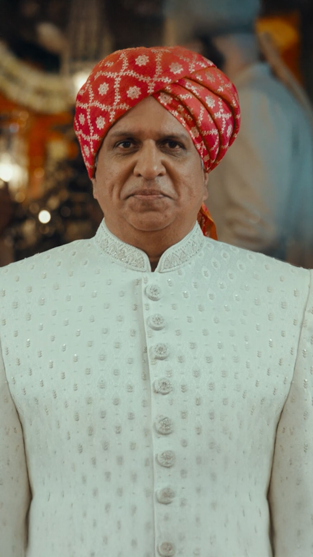 Father dressed in a classic white kurta paired with a red safa, perfect for pre-wedding celebrations.